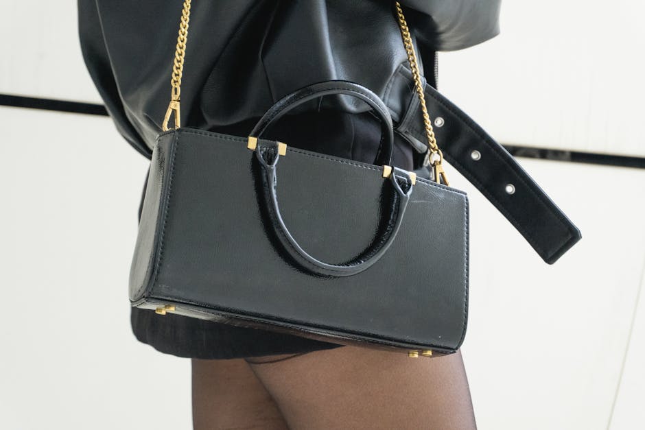 Stylish black leather handbag with gold chain strap, perfect for chic and modern outfits.