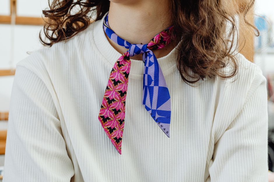 Close-up of a woman wearing a colorful patterned scarf, showcasing fashion elegance.