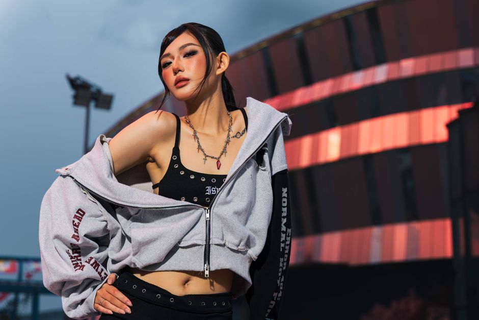 Stylish woman modeling streetwear at night in Ho Chi Minh City.