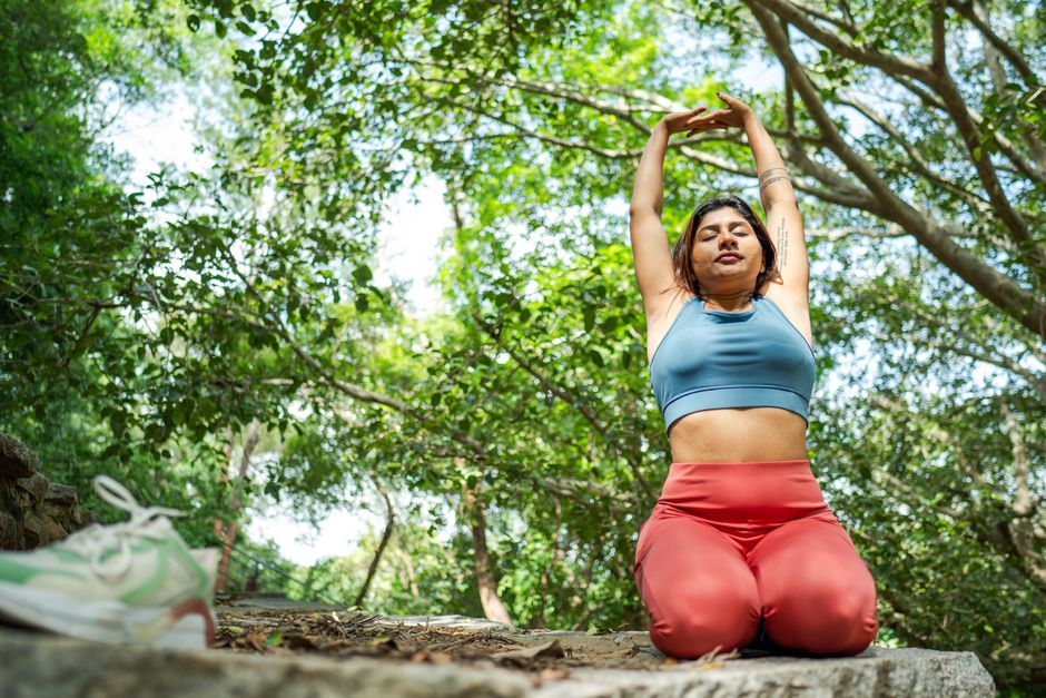 Woman practicing yoga in peaceful forest setting, embracing wellness and mindfulness.