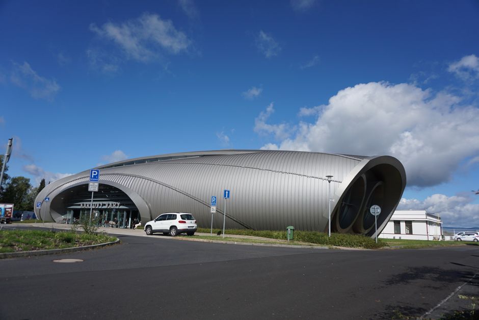 Futuristic building with unique design under a clear blue sky, showcasing modern architecture.