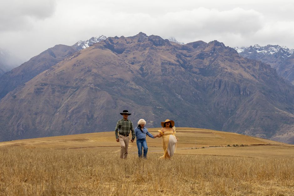 A family walking hand-in-hand in a picturesque mountainous landscape, capturing a serene outdoor moment.