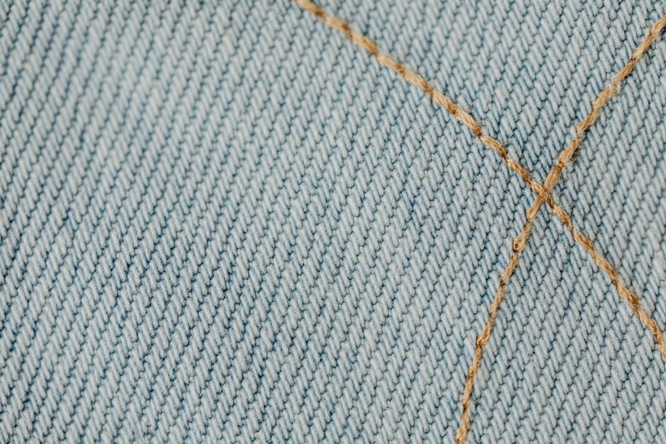 Detailed close-up showing intricate stitching on blue denim fabric.