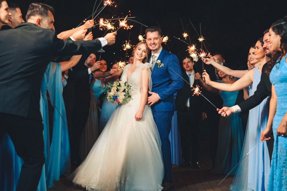 Joyful wedding night with sparklers and a happy couple surrounded by friends.