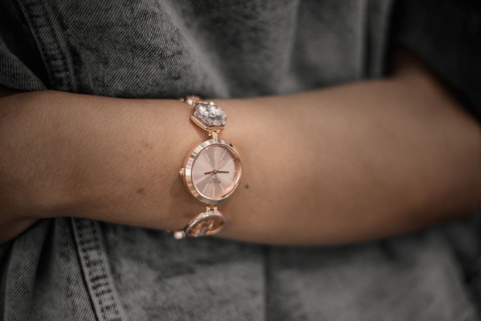 Close-up of a rose gold wristwatch worn by a woman, showcasing elegance and fashion.