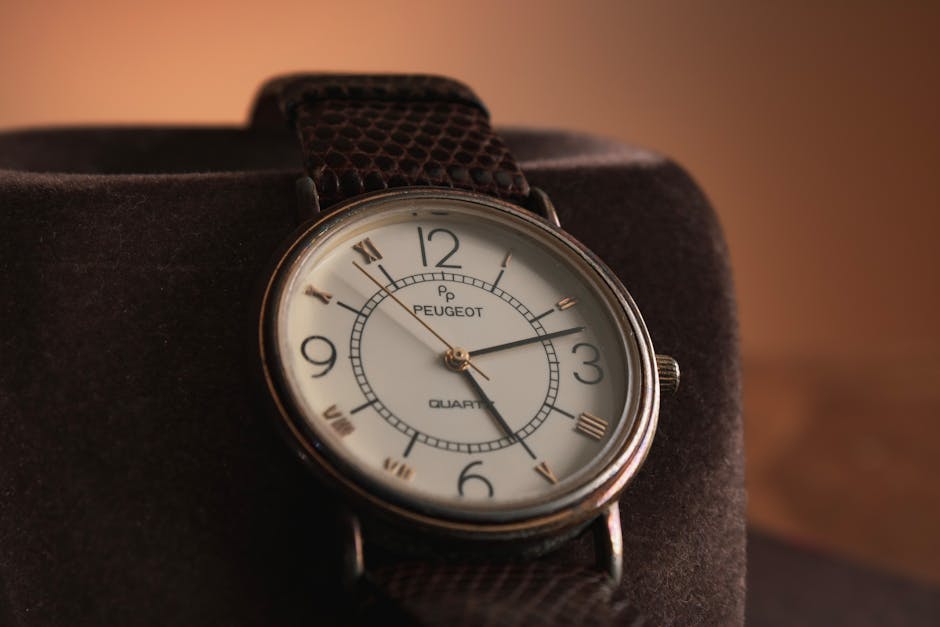 Close-up of a vintage Peugeot wristwatch with a leather strap.