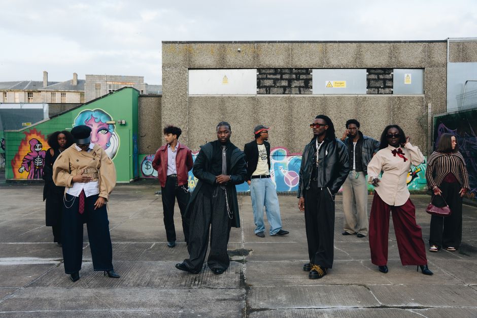 Stylish group in urban setting with graffiti art. Diverse fashion.