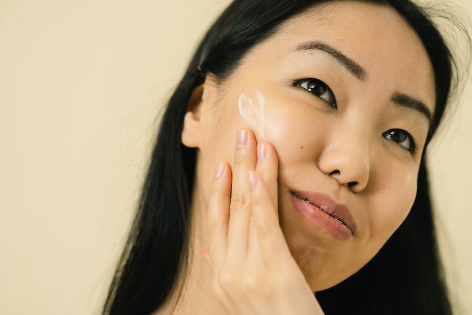 Woman applying sunscreen to her face