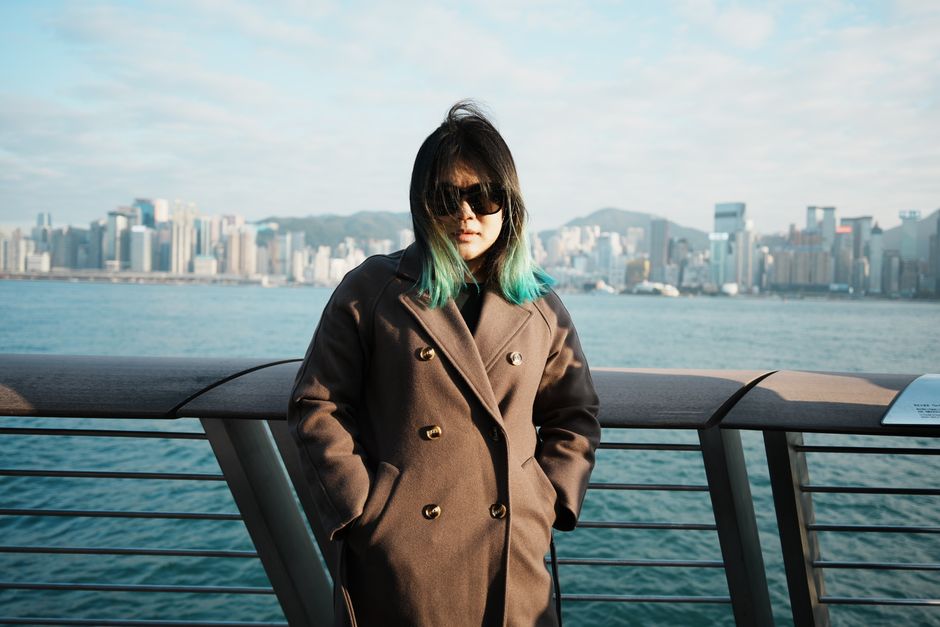 Woman in a long wool coat by the waterfront in winter